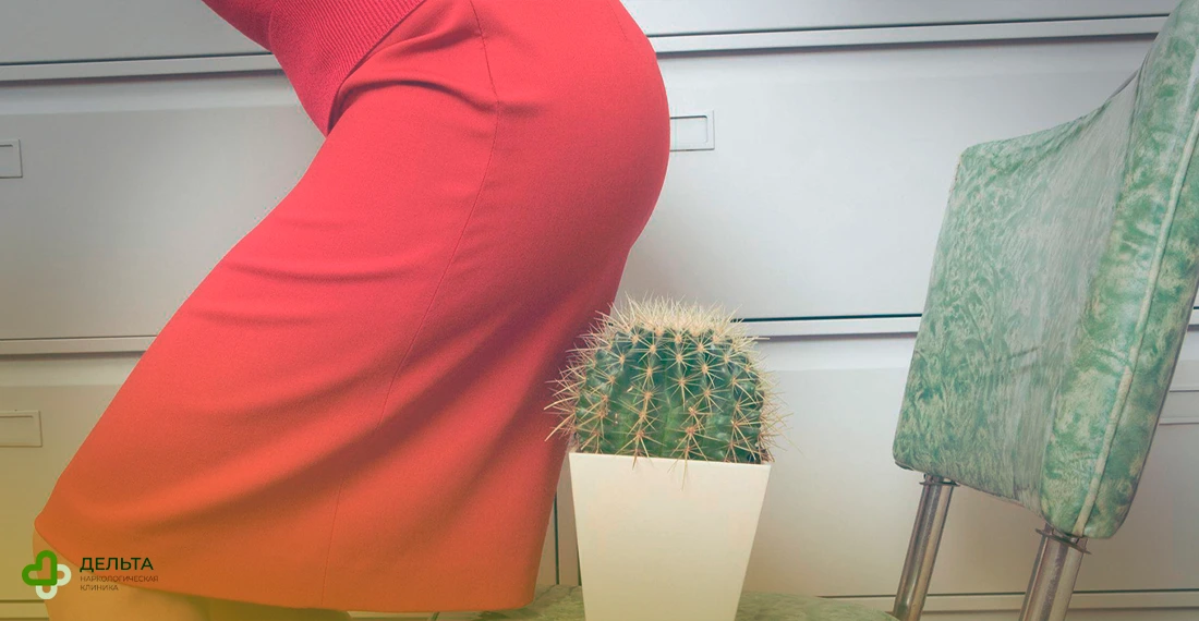 Женщина в красной юбке садится на стул, где стоит кактус